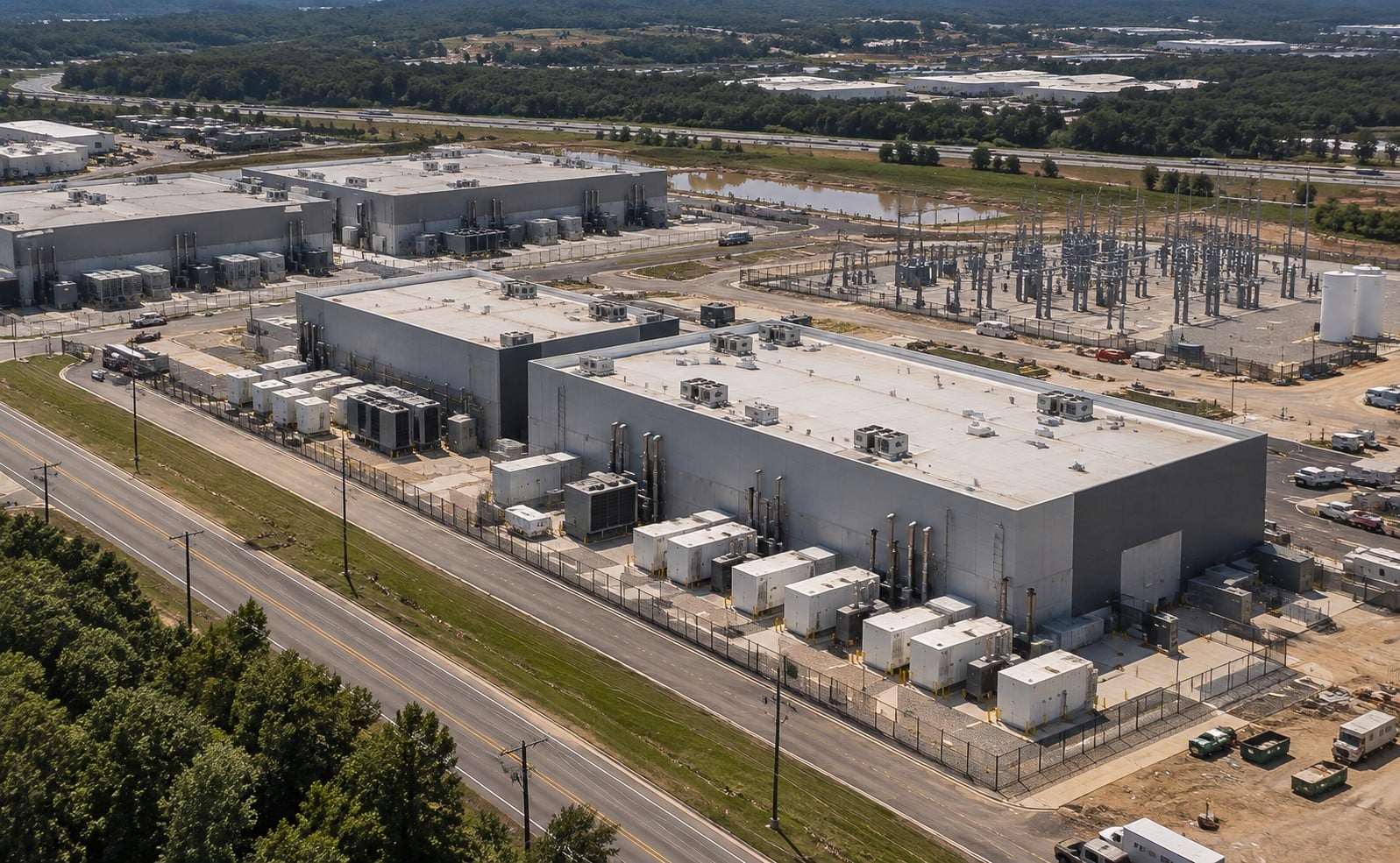 Aerial view of a data center campus beside a high-voltage electrical substation